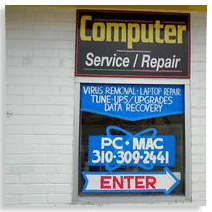 A computer repair shop sign on the side of a building.